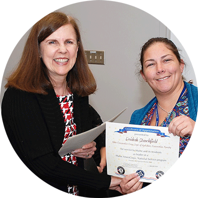 Two individuals pose for a photo during an award ceremony