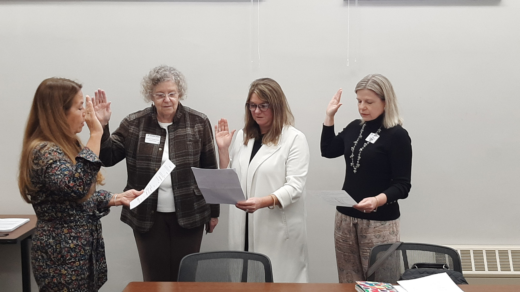 4 women with right hand raised to take oath of office