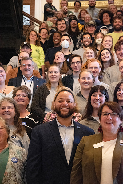 group of AmeriCorps members standing on staircase with AmeriCorps leader, Michael Smith in front of them