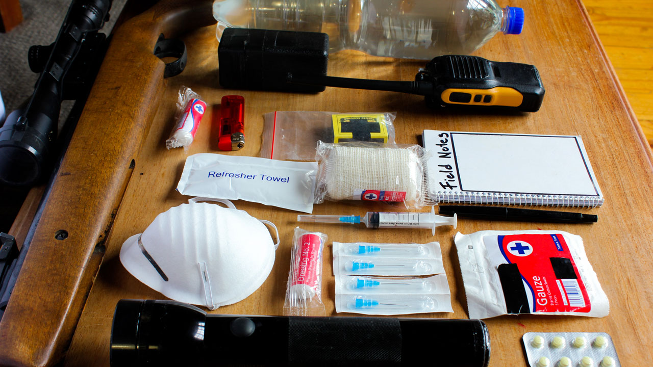A collection of supplies used to respond to emergencies placed on a wooden table