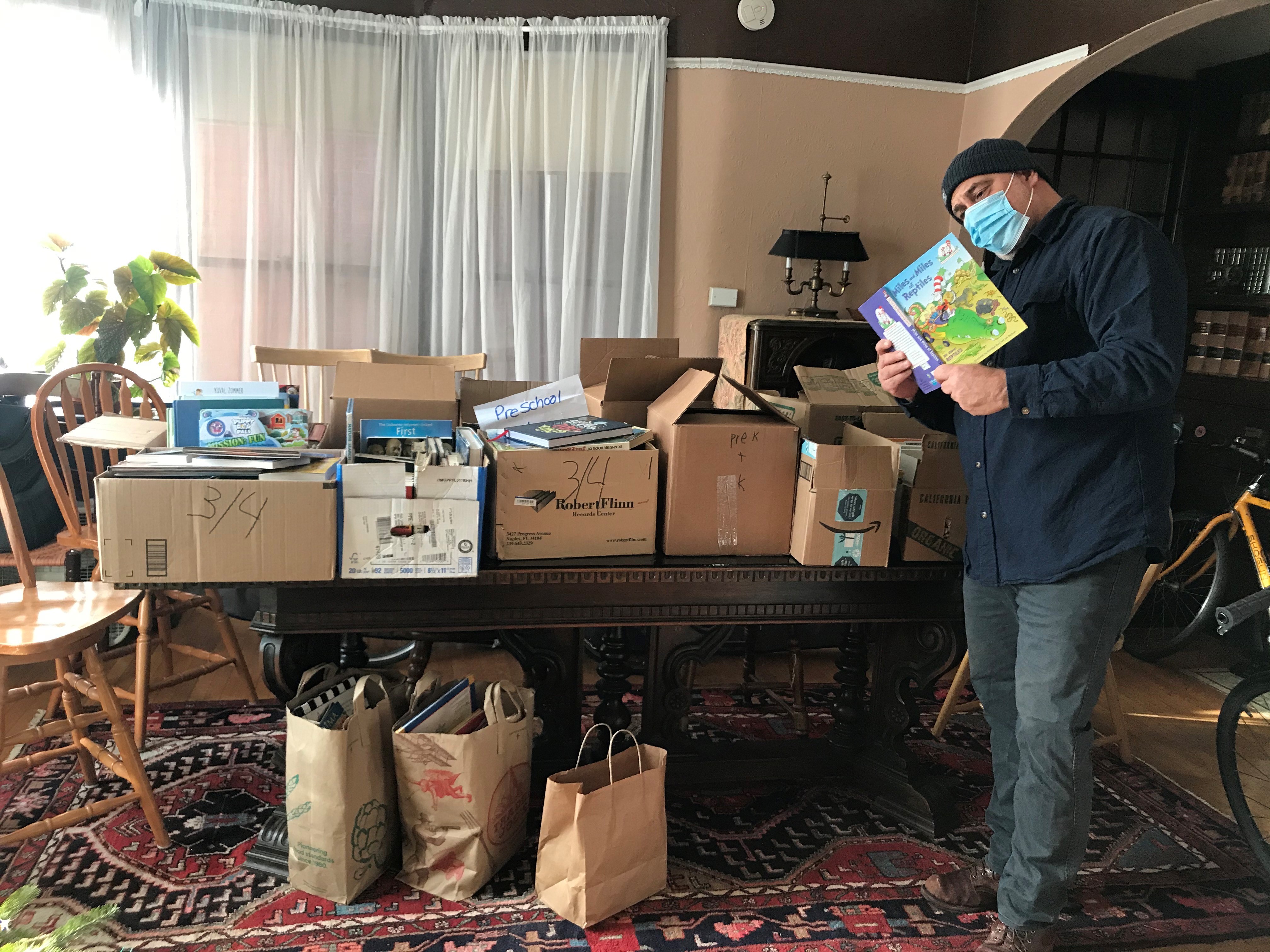 person sorting books in a living room