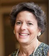 Picture of a woman with short gray hair smiling into the camera
