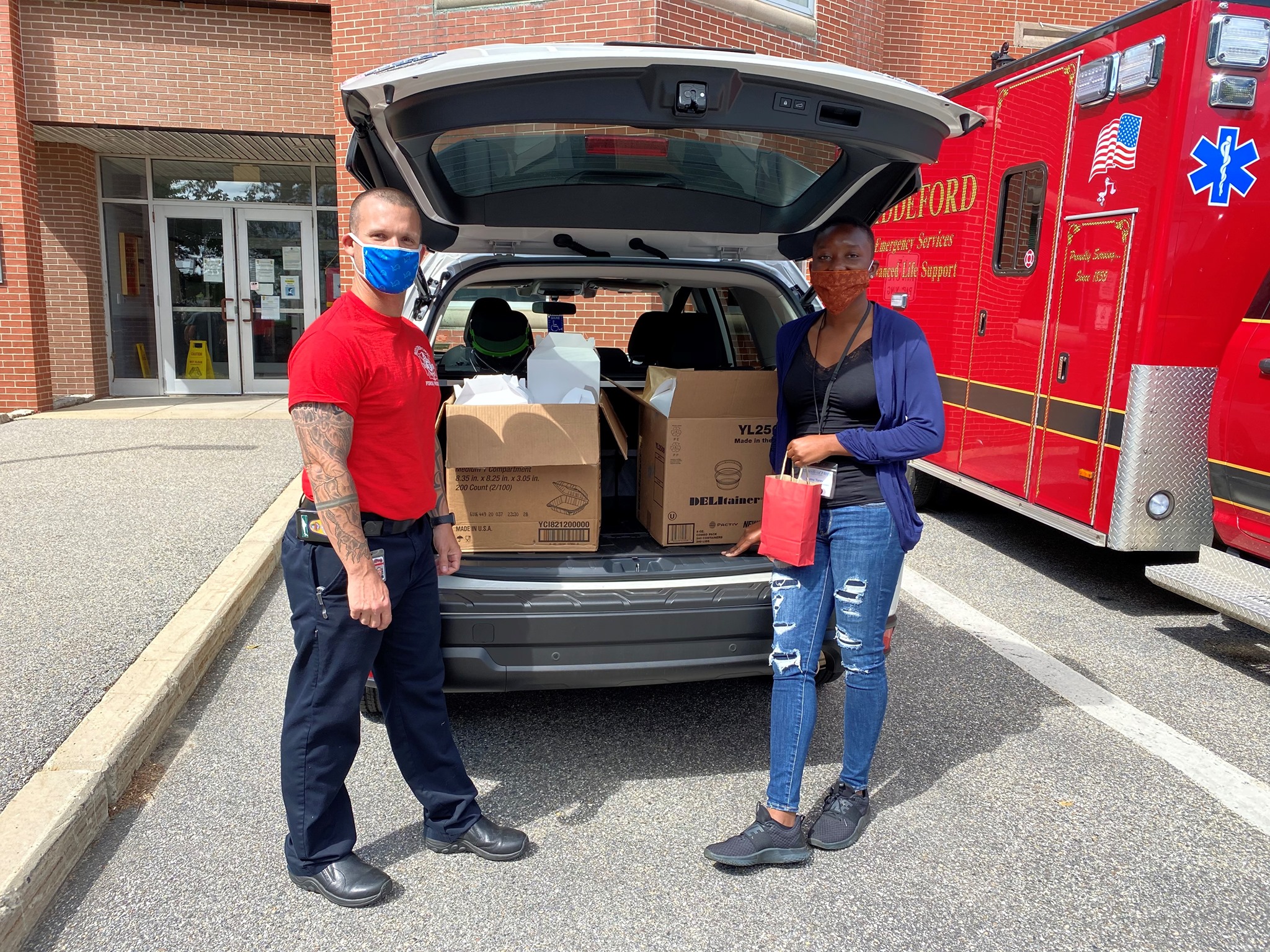 two people facing camera with lunch bags in hand