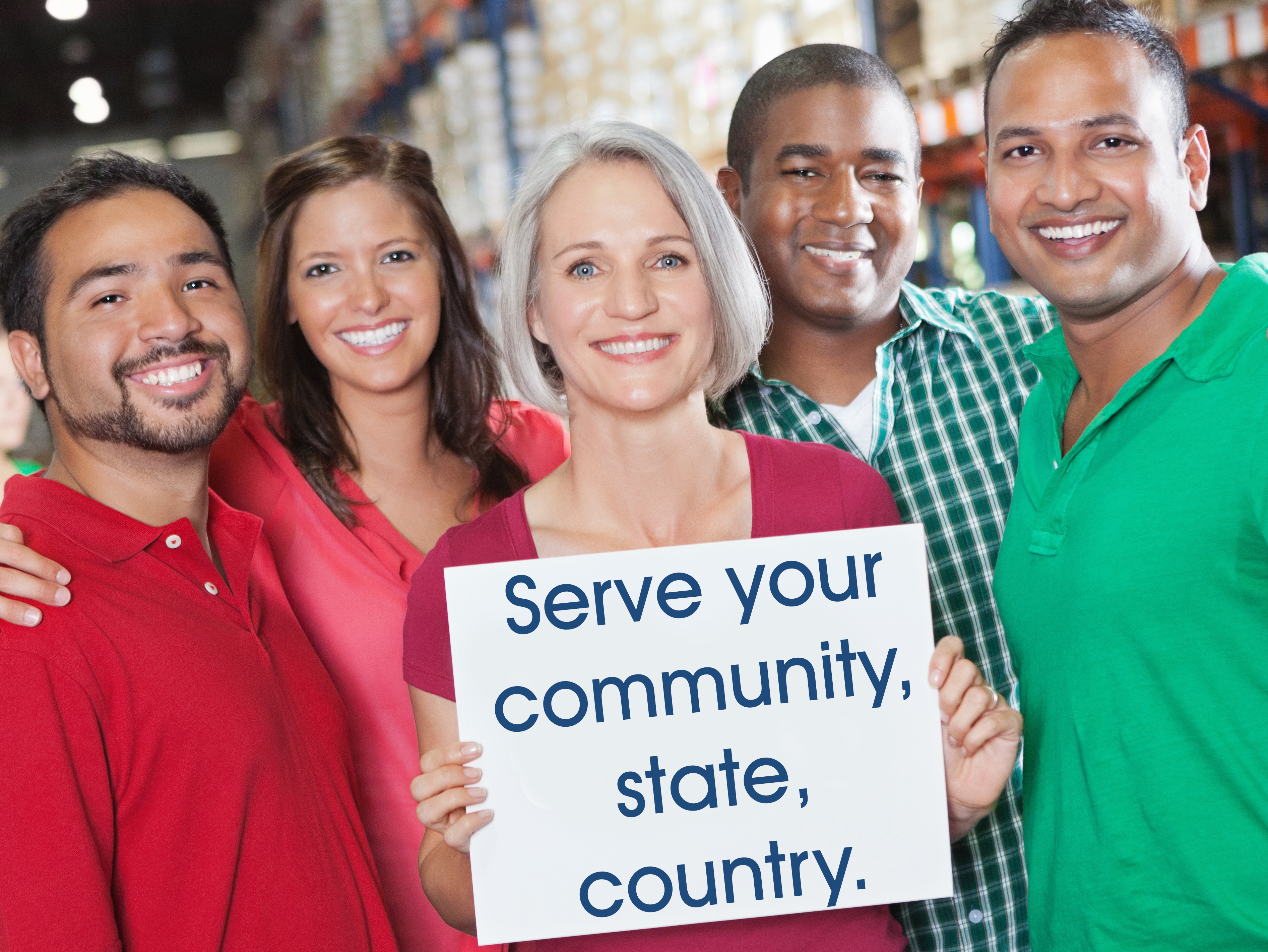 Three men and two women standing shoulder to shoulder with a sign